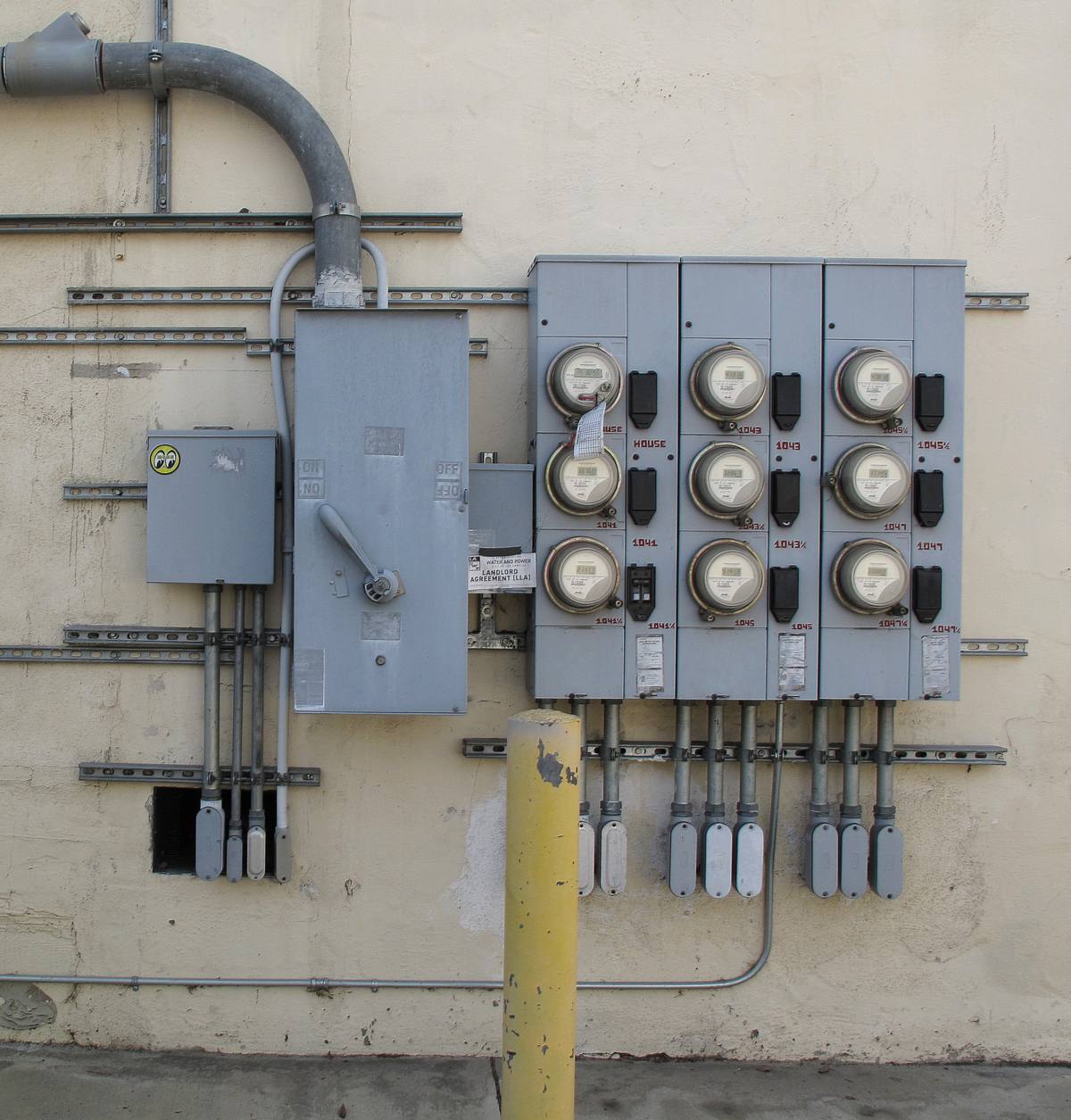 Bir binanın dış cephesinde sıralanmış elektrik sayaçları ve şalter panoları